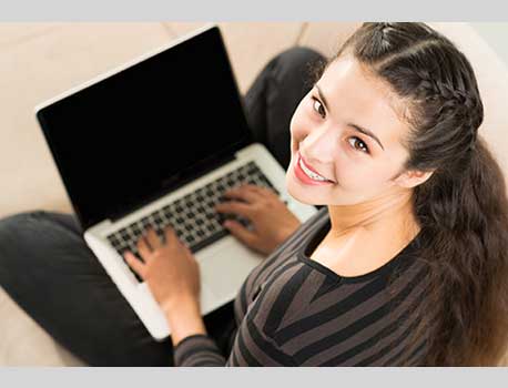 Smiling girl using a laptop