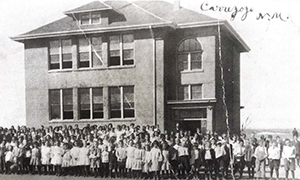 Front view of Carrizozo High School and students surrounding it in 1924