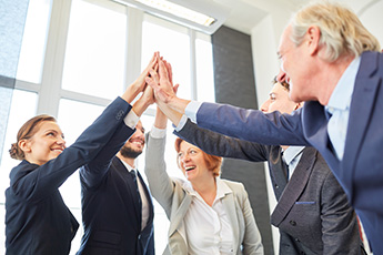 Group of adults with the hands raised in a high-five